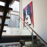 Colin and Anita designed the open steel and glass staircase to allow natural light to filter through from all sides. The painting is by Janice Krangle of Toronto.