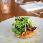 Chef Guinto’s Pithivier is a delicate pastry encasing a rich filling of squash, mushroom, kale, caramelized onion and goat cheese, topped with local baby greens.