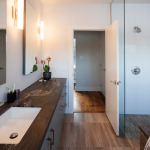 A limited palette of materials was used throughout the house. In the master bathroom the floors are large format limestone tile and the granite counter has a leather-like finish.