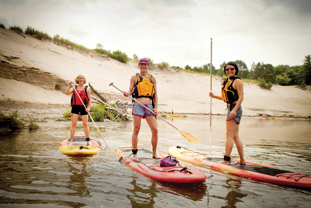 Jennie Elmslie of Free Spirit Tours (left) gives a SUP lesson to Pam Paylor (centre) and Sonya Reiner.