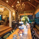 A custom-made dining table seats as many as 20 guests. Barn board lines the vaulted beamed ceiling and Elmira yellow brick covers the inside wall.
