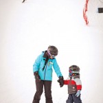 Ski school instructor Emma Pawlick helps a little one get comfortable on skis.