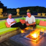 SueAnn Wickwire and Stephen Headford enjoy their new firepit from Restoration Hardware. The wooden sculptures are by Creemore artist Ralph Hicks.