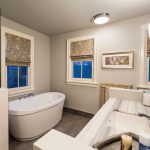 The master bathroom has a walk-in shower and a deep soaker tub reminiscent of the “pod” shape.