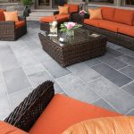 The latest trends in patio design include covered patios and flagstone patios at ground level that are an extension of the indoor space.