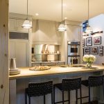 The kitchen pine cabinetry was painted a soft grey for a more contemporary look. Pendant lights over the kitchen island are from Hollace Cluny.