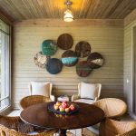 A screened porch off the kitchen is well used in summer. Designer Kimberley Seldon found the wall art (made from oil tin tops) at the North Carolina Art Crawl.