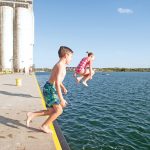 Claire and Reed Johnson jump off the Collingwood pier beside the grain terminal.