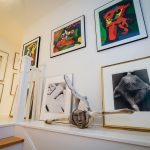 A whalebone Inuit sculpture bought at Huston Gallery North in Lunenburg, Nova Scotia rests on the stair landing between two of the owner’s collection of art and fashion photographs. The prints above the sculpture are by Karel Appel.