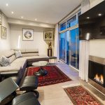 A gas fireplace that took up too much space in the living room was replaced with a simple flat-to-the-wall design from Chantico Fireplace Gallery. To the left of the fireplace, two sets of sliding doors open to the deck and water view.