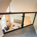 Tthe view from the loft into the family room is enhanced by clear glass panels.