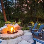 Vidas Augaitis and his partner, Jone Panavas, enjoy their newly installed gas firepit. Muskoka chairs made of recycled plastic are from Squire John’s.