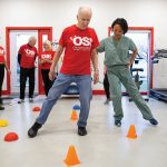 Dr. Olivia Cheng (centre right), helps Jim O’Brien (centre left) through an obstacle course as part of the Peer Health Initiative.