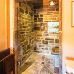 The bathrooms all feature the same organic elements of stone, clay and wood. Black is used consistently as an accent colour.