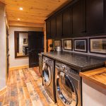 The natural look of reclaimed wood and leathered granite countertops extends to the laundry room, which is also a passage way to the garage.