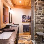 The bathrooms all feature the same organic elements of stone, clay and wood. Black is used consistently as an accent colour.