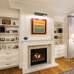 A gas fireplace warms the master bedroom and built-in shelves display family photos. Behind the drapes are sliding doors that open to the covered porch.