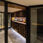 A custom-designed wine cellar is tucked beneath the stairs to the lower level and features design elements consistent with the rest of the house.