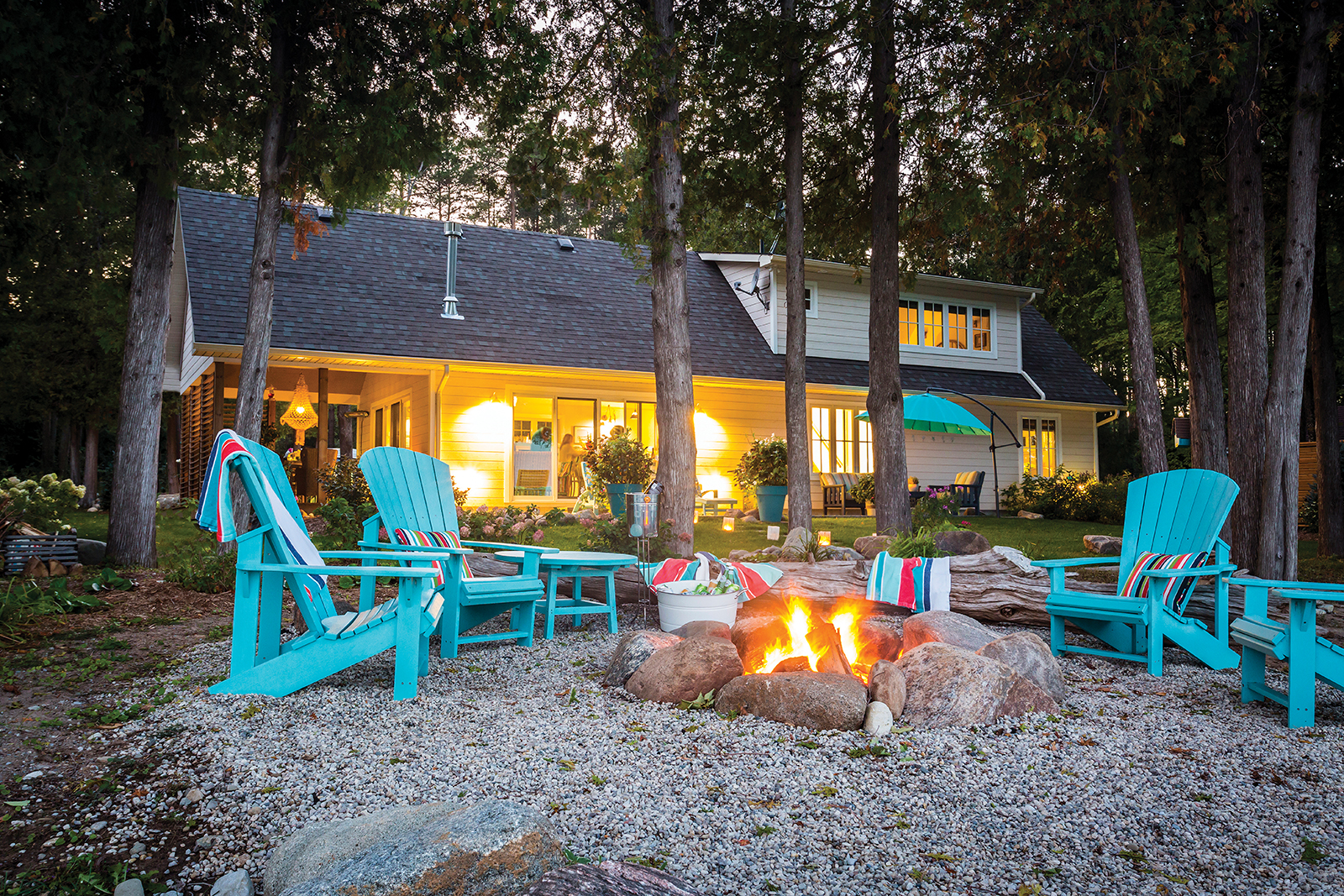 Durable Muskoka chairs from CR Plastic Products form a semi-circle around the firepit behind this waterfront cottage on Kiowana Beach in Meaford.