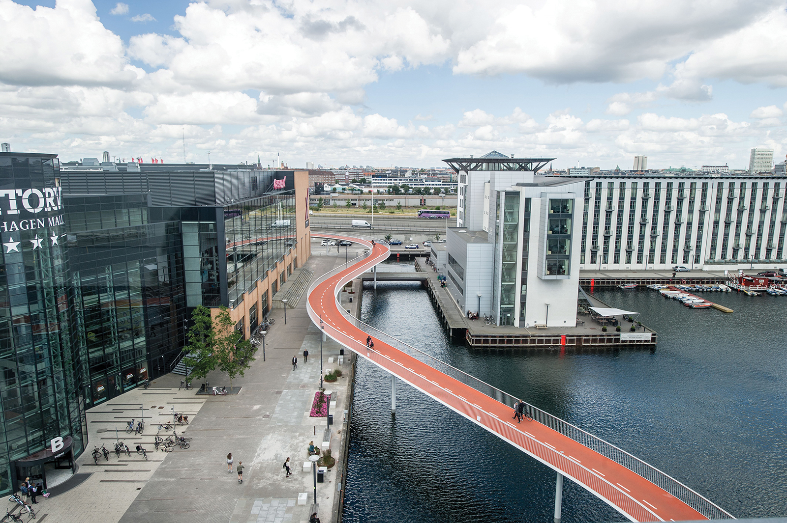 The Bicycle Snake in Copenhagen, Denmark transports cyclists across the harbour. Once down at ground level, the bridge connects with Bryggebroen, another bike bridge that enables cyclists to safely get from one side of the city to another.