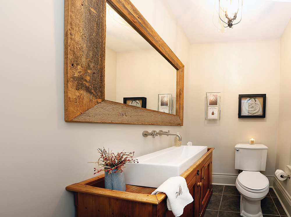A vintage dry sink was turned into a vanity in the ground floor powder room. The mirror frame is salvaged wood.