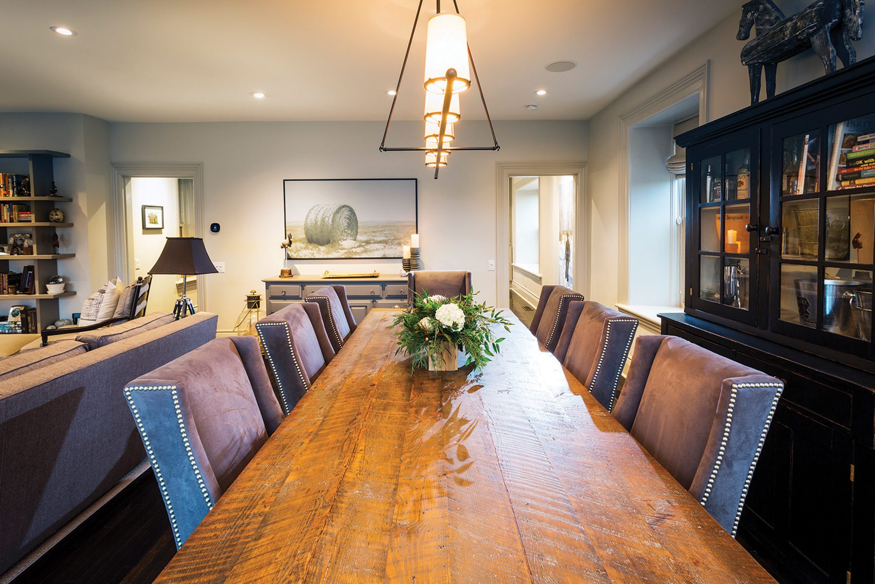 The reclaimed hemlock dining table can seat 12. Maxwell designed the black iron and glass light fixture.
