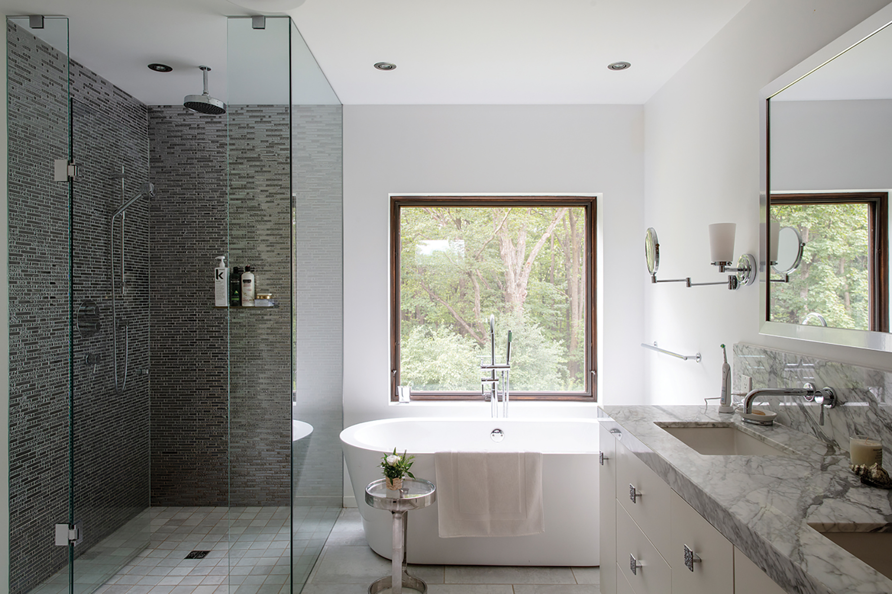 The master bath boasts a soaker tub with a view, a glassed-in shower and Carrara marble vanity top.