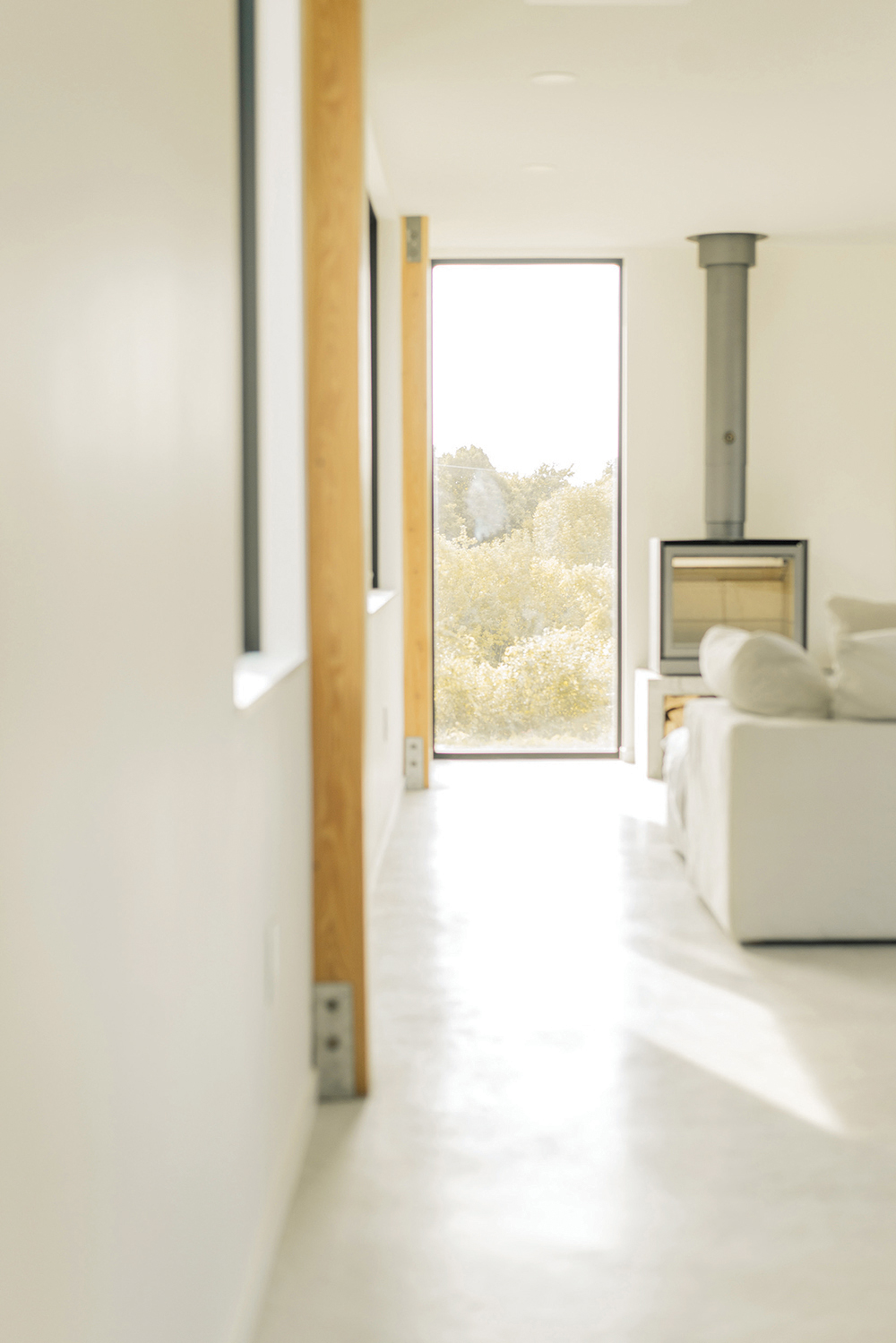 Polished concrete supports both the modern feel, and the fireplace/woodstove (from The Fireplace Stop) to code-height above the floor.