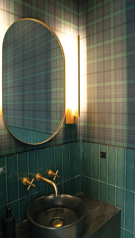 The main floor powder room, finished in plaid wallpaper, is Clare’s homage to her Scottish heritage.
