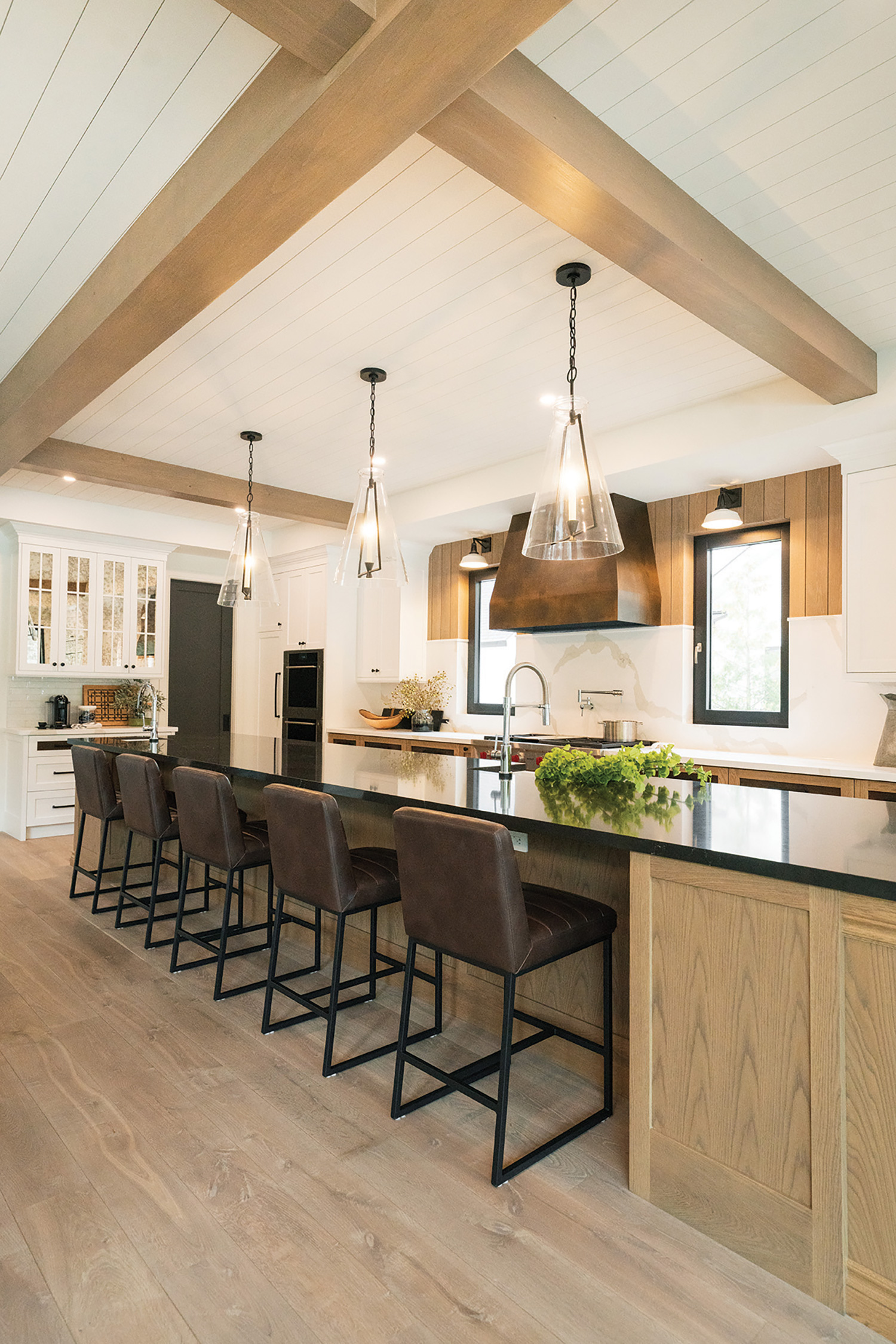 Barn beams, shiplap and honey-coloured wood add warmth to a chalet kitchen made for entertaining.