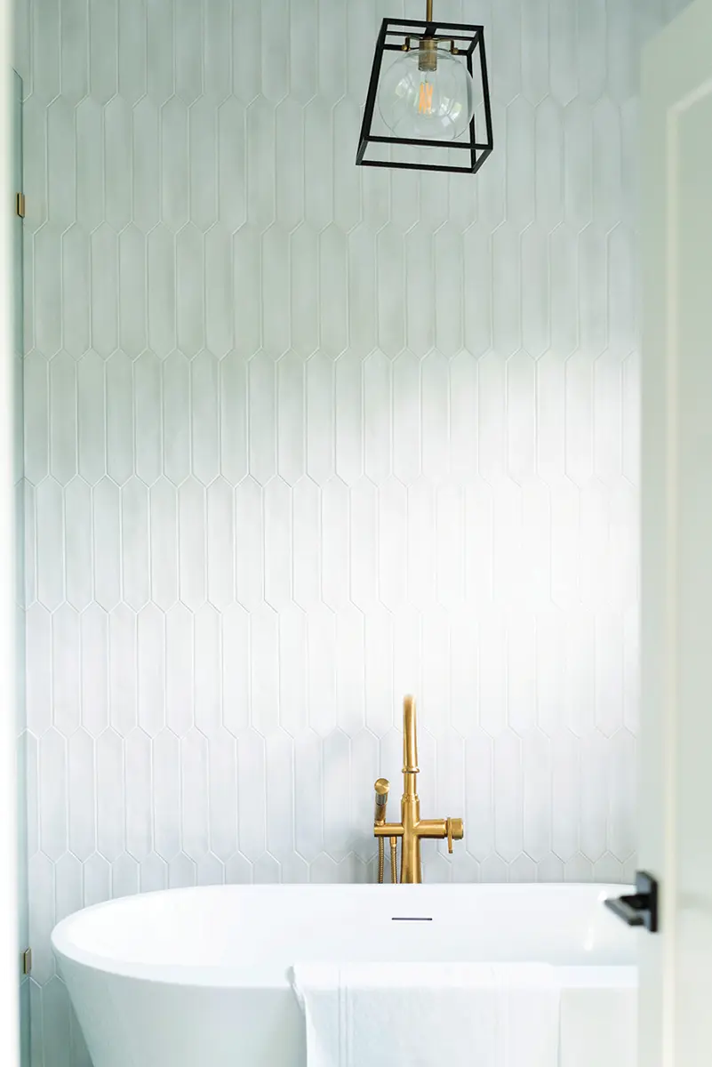 The light-filled primary bedroom and bathroom are a study in warm tones on white.