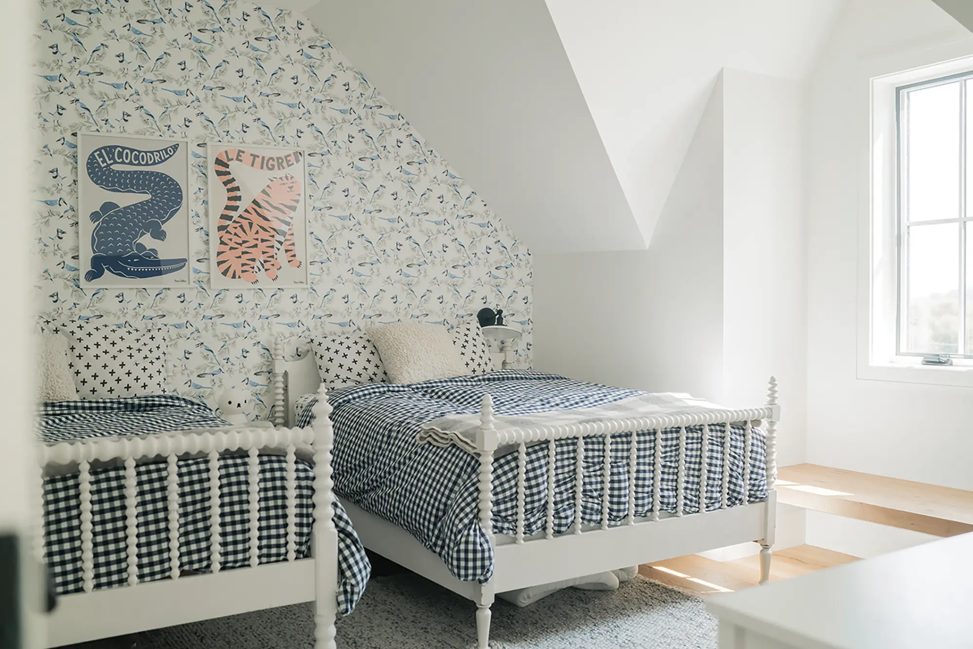 Light fills the main floor primary bedroom. Blue jay wallpaper by Kate Golding from Memo showroom accents the boys’ room.