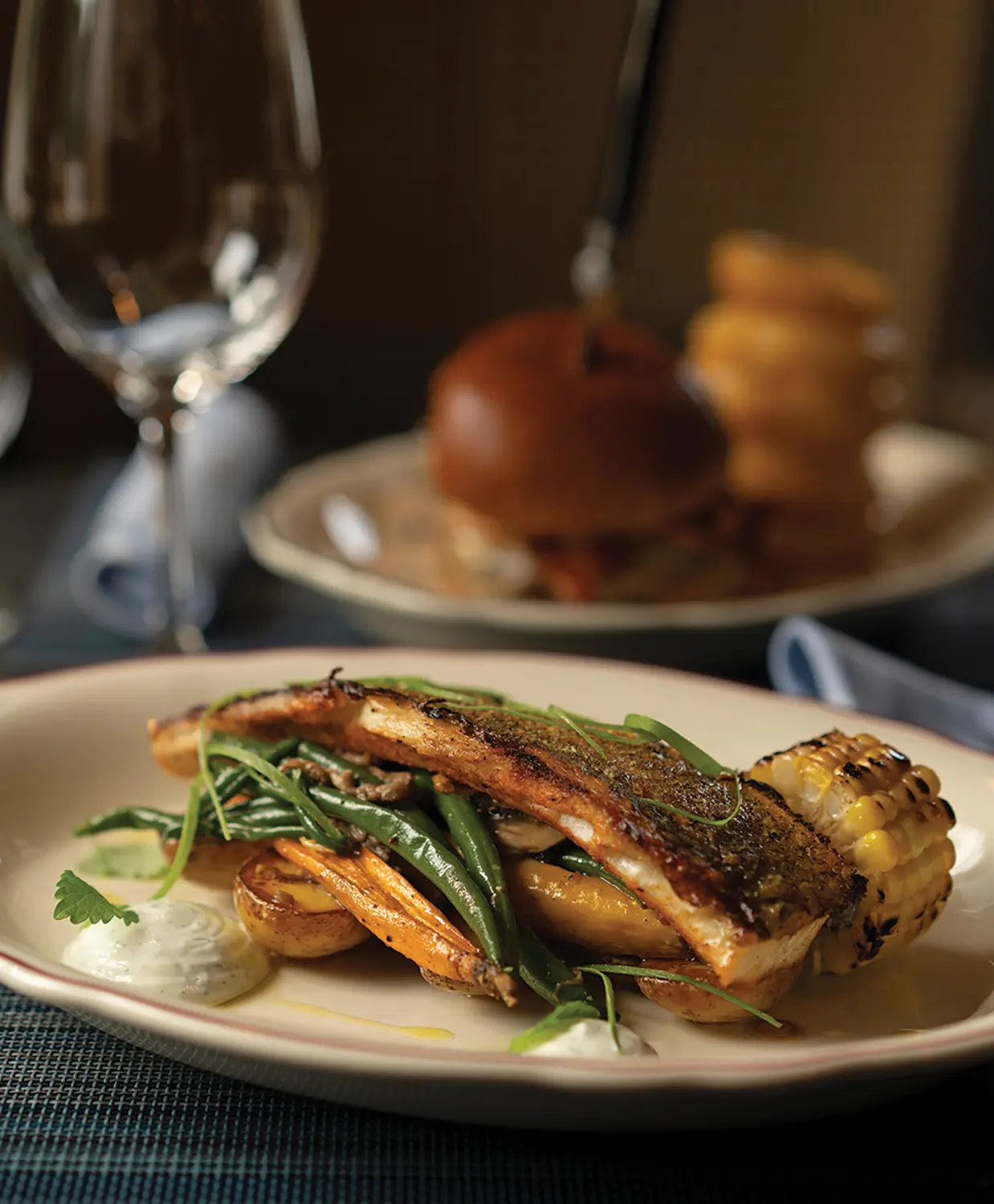 Roasted BBQ-spiced pickerel and the six-ounce tavern dry-aged steak burger with onion rings.